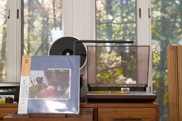 Tom Skinner - Kaleidescope Visions LP cover.

A teal border with an insert picture of Skinner, distorted. An OBI runs down the left.

The yellow LP plays on a vintage, restored Bang & Olufsen Beogram 4000 linear-tracking turntable to the right.